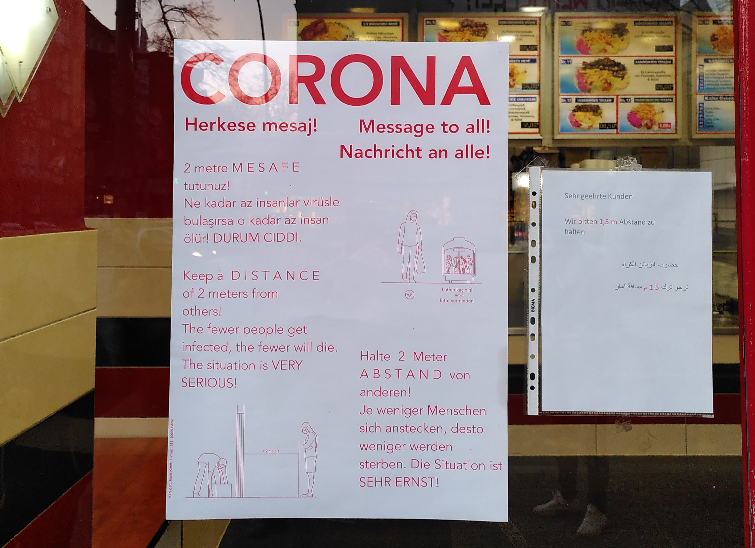 Ein Plakat vor einem Imbiss fordert Kund*innen zum Abstand halten auf