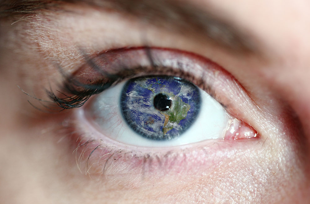 Close-up of an eye, where the pupil shows the world