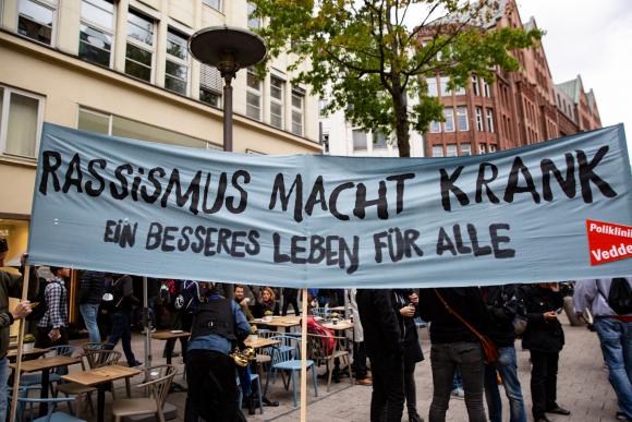 Ein Transparent mit dem Spruch "Rassismus macht krank"