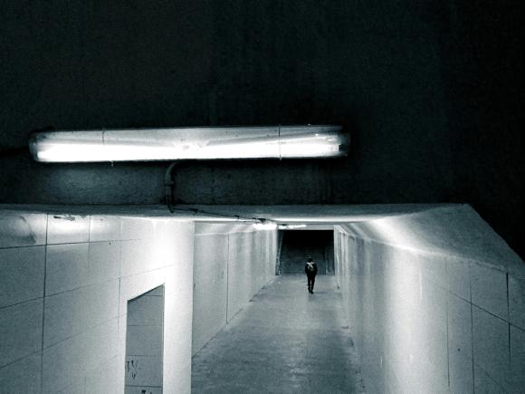 Ein Tunnel oder eine Unterführung in schummrigem Licht, weiter hinten läuft eine Person