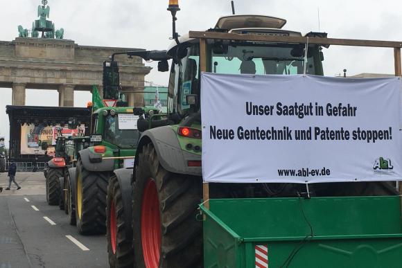 Traktoren mit Bannern vor dem Brandenburger Tor, eines trägt die Aufschrift 'Unser Saatgut in Gefahr - Neue Gentechnik und Patente stoppen'